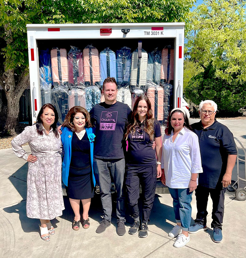 Image of the CharityRx team of two men and two women with representatives of Angels of Grace and CASA who received the suitcases CharityRx donates.