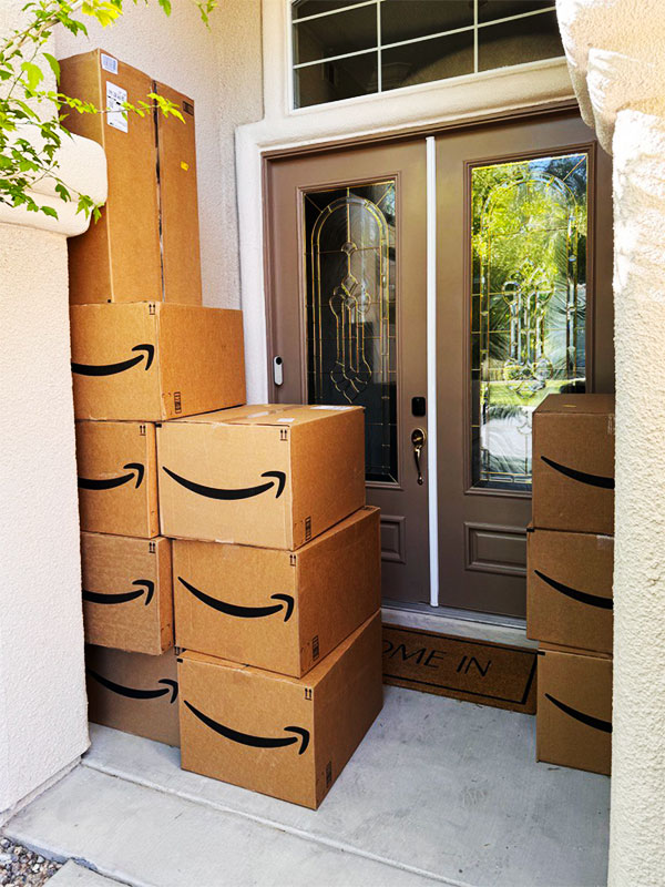 Image of 11 large boxes stacked on the porch of a house. CharityRx donates