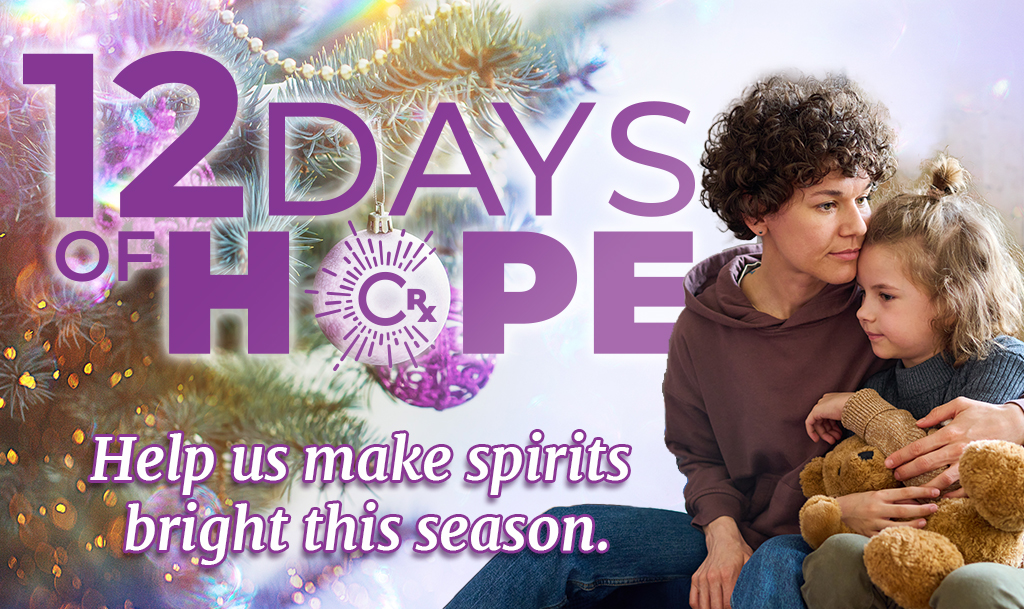 A worried-looking young mother holds her daughter close over a background of a decorated Christmas tree. Text reads: CharityRx 12 Days of Hope. Help us make spirits bright this season.