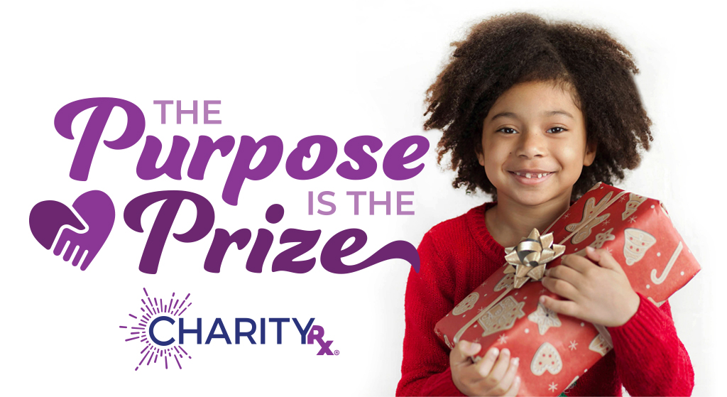 At CharityRx, the purpose of 12 Days of Hope is the prize. A smiling young girl holds a gift wrapped in red and gold Christmas paper. 